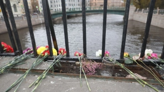Петербуржцы продолжают нести цветы к месту падения автобуса в Мойку