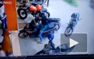 Девушка выезжает с парковки на скутере.