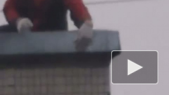 Петербуржец, рискуя жизнью, чинит крышу под ураганным ветром