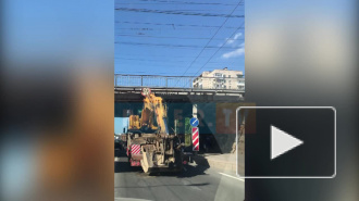 На Ланском шоссе грузовик с трактором на трале застрял под мостом