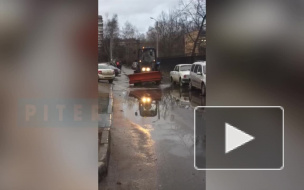 На шоссе Революции трактор разгонял лужи ковшом